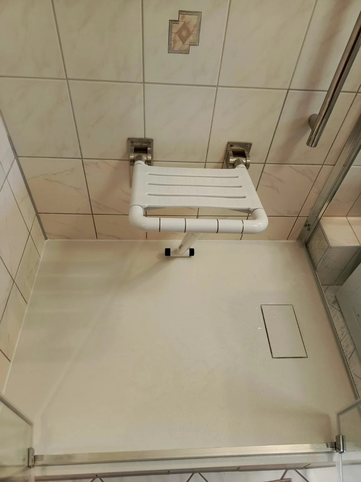 Detail: Klappbarer Duschsitz und Ablauf im modernisierten Duschbereich.