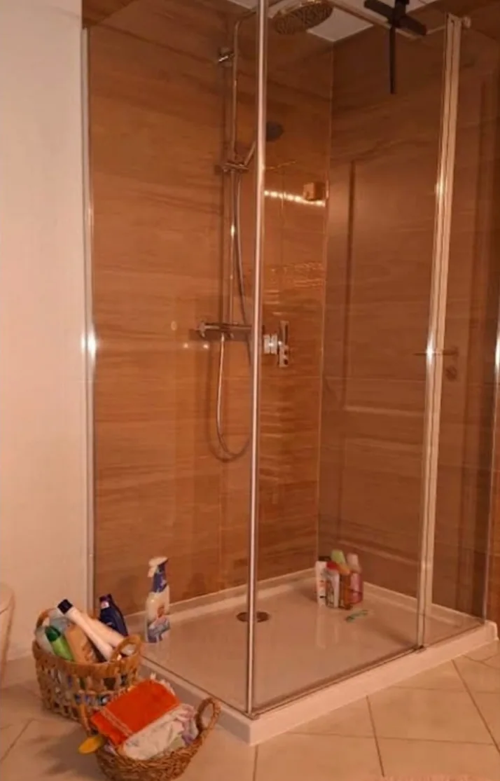 Nachher: Duschkabine und Wandfliesen in warmer Holzoptik.
